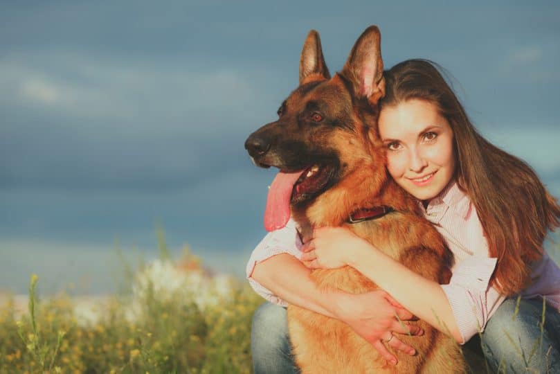 Young woman hugging a German shepherd